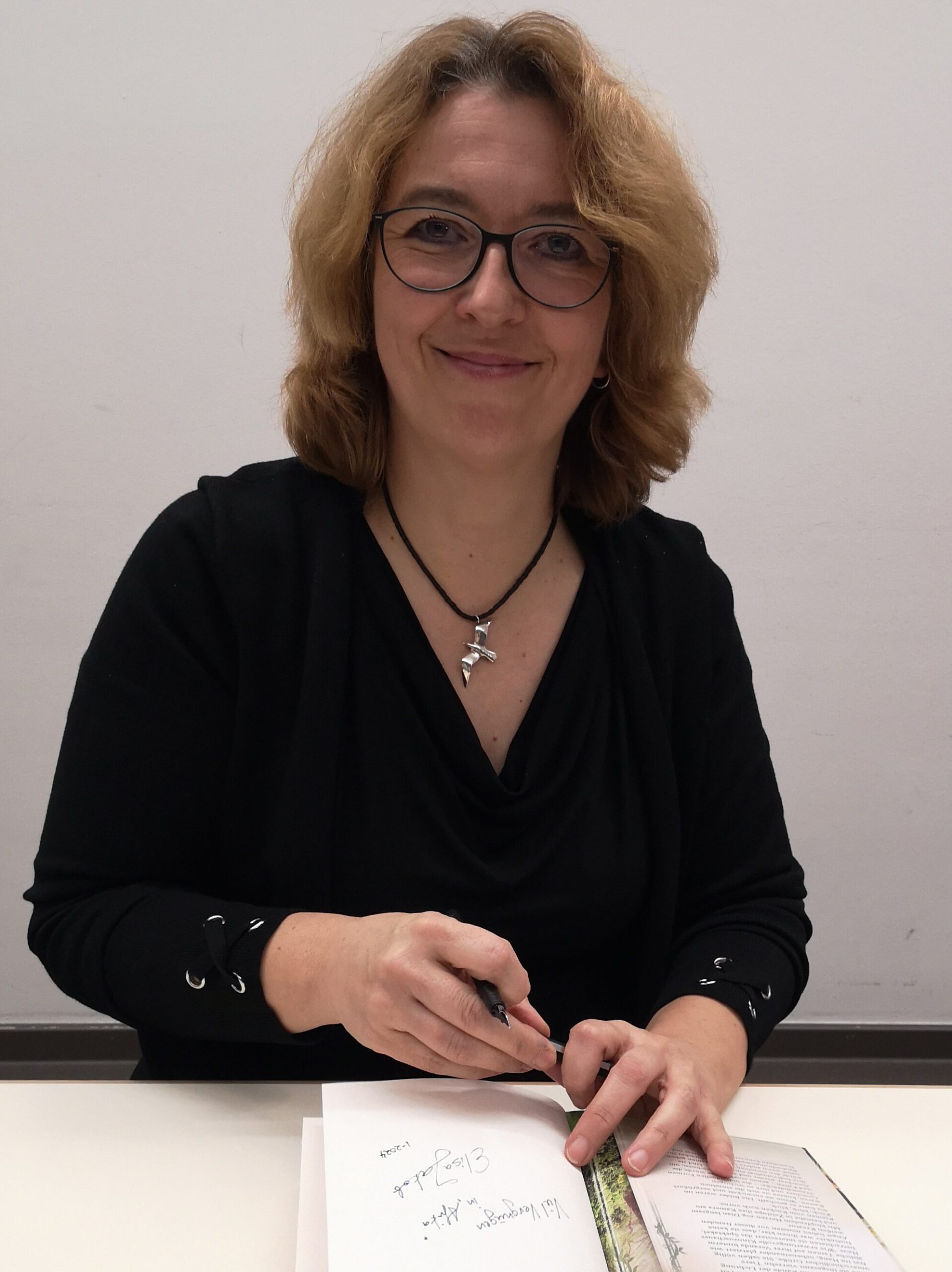 Elisa Jakob signiert ein Buch